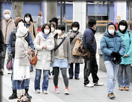 マスク着用で街を歩く市民
